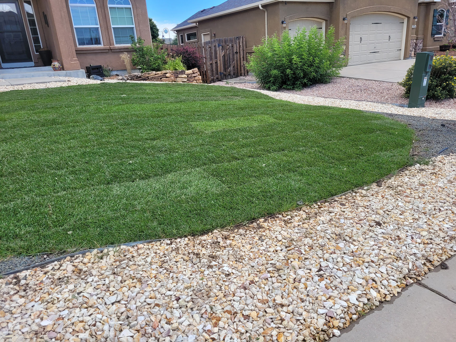 Fresh green lawn with decorative rock border